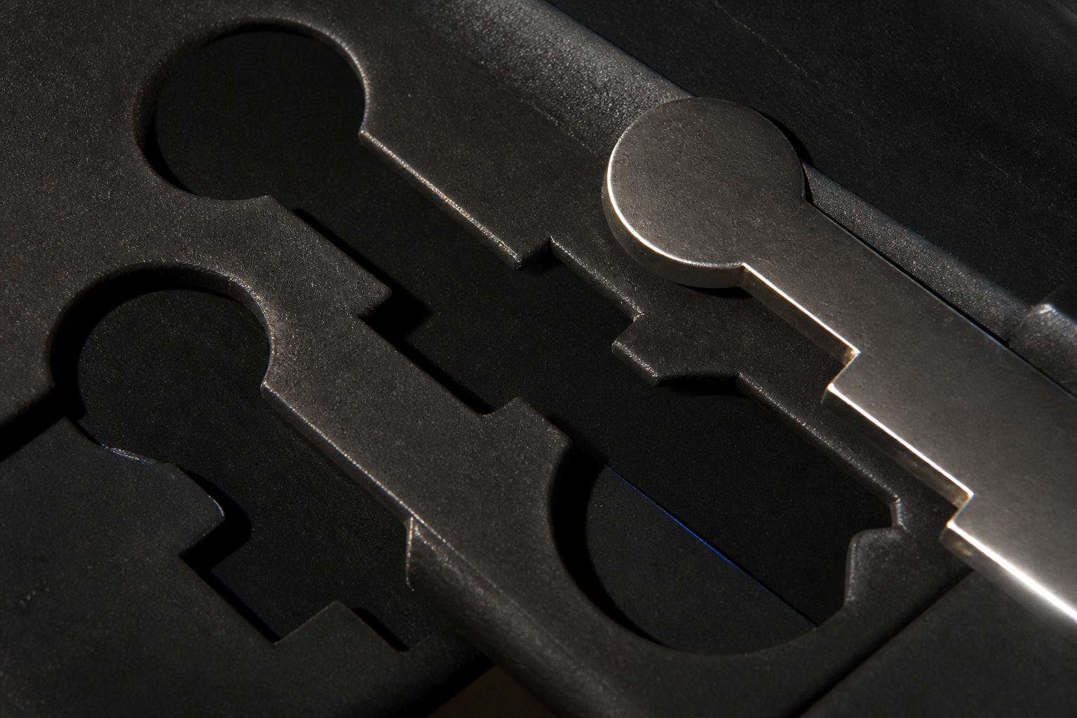 Warding silhouettes and shear marks on a dark rubber bench
